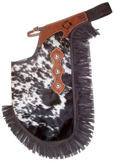 a black and white cowhide saddle with fringes