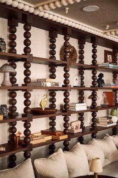 a living room filled with lots of furniture next to a wall covered in bookshelves