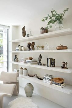 the shelves are filled with vases, books and other decorative items in this modern living room