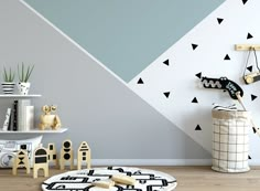 a child's room decorated in black and white with triangles on the wall, toys and bookshelves