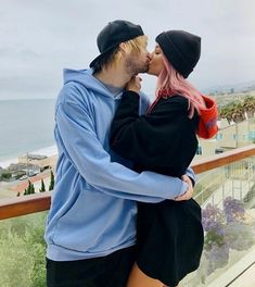 a man and woman are kissing on the balcony