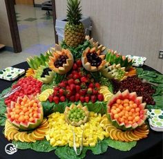 a table topped with lots of fruits and vegetables on top of a black table cloth