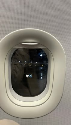 an airplane window with a person looking out at the city from it's seat