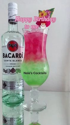 a pink and green drink next to a bottle of bacardi gingeze