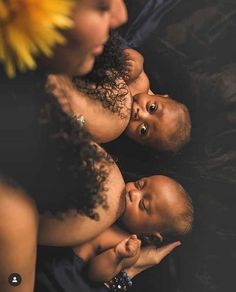 three babies are laying on their mother's lap and looking up at the camera