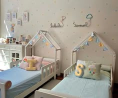 two beds in a child's room with decorations on the wall