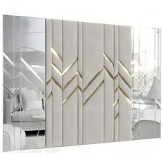 a mirror with gold lines on it and a white couch in the reflection behind it