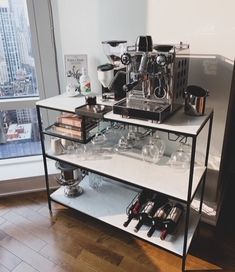 a coffee machine sitting on top of a white shelf filled with glasses and other items