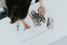 a woman is working on some art work with scissors and pencils in her hands