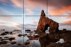 an image of a rock outcropping in the ocean at sunset or sunrise