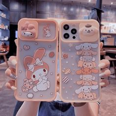 someone holding up two cell phones with cartoon animals on them in front of the camera