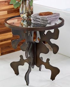 a table with towels and flowers on it in front of a bath room tub area