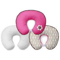 three travel pillows, one in pink and the other in white with flowers on them