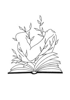 an open book sitting on top of a table next to a leafy plant in the shape of a heart