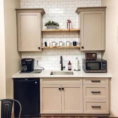 a kitchen with white cabinets and black appliances