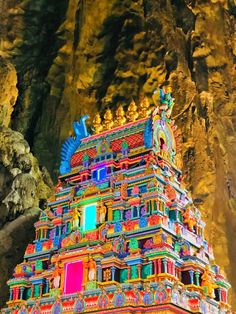 an elaborately decorated temple in the middle of a mountain side area with large rocks on both sides