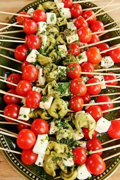 the food is being served on skewers with tomatoes and other vegetables in them