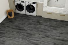 a washer and dryer sitting in a bathroom next to each other on the floor