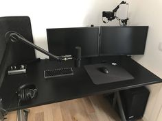 a computer desk with two monitors and a mouse