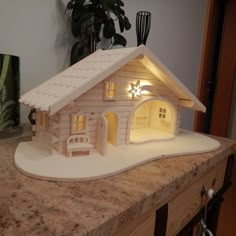 a small wooden house sitting on top of a counter