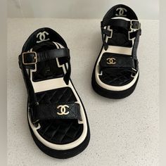 100% Authentic! These Sandals Are In Very Good Condition. Chanel Lambskin Logo Platform Sandals Eu 37 Us 7 Black White 22p These Stylish Sandals Are Crafted Of Black, And White Lambskin Leather. These Sandals Feature Velcro Ankle Straps And Gold Cc And Chanel Logos On The Straps. Luxury Leather Wedge Sandals With Padded Heel, Luxury Synthetic Sandals For The Beach, Luxury Synthetic Beach Sandals, Black Leather Sport Sandals With Open Heel, Black Flat Sandals With Heel Strap, Luxury Open Toe Platform Sandals, Black Leather Sport Sandals For Summer, Black Leather Wedge Sandals With Padded Heel, Designer Platform Sandals With Ankle Strap