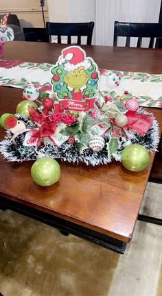 a christmas centerpiece on a table with apples and other holiday decorations in front of it