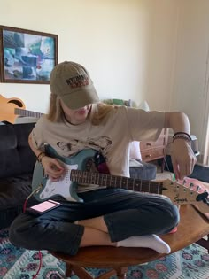 a woman sitting on top of a wooden table holding an electric guitar