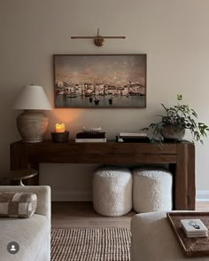 a living room filled with furniture and a painting on the wall above it's desk