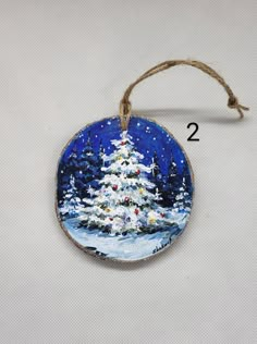 a christmas tree ornament hanging from a string on a white background with the number two