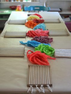 the table is covered with many different colored pieces of cloth and thread on top of each other