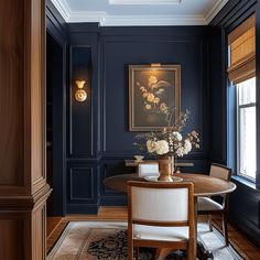 an elegant dining room with blue walls and wood trim