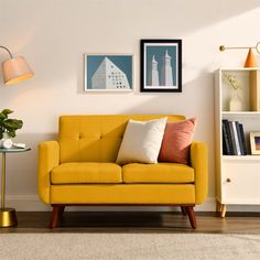 a living room with a yellow couch and two framed pictures on the wall above it