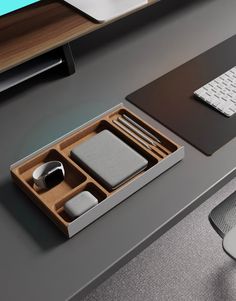 an office desk with a keyboard, mouse pad and other items in the trays