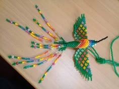 a colorful bird made out of beads on a table