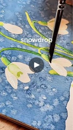 a painting with flowers on it and a pen in the foreground that says snowdrop