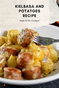 a white bowl filled with potatoes and meat on top of a table next to a fork