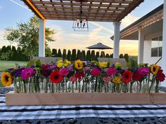 a bunch of flowers sitting on top of a table under a pergolated roof