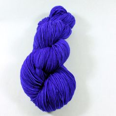 a skein of purple yarn on a white surface