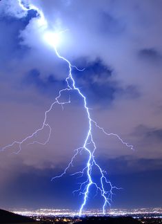 a lightning bolt is seen in the sky over a city