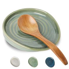 a wooden spoon sitting on top of a green plate next to four different colored plates