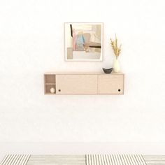 an empty room with a shelf and vase on the wall, next to a striped rug