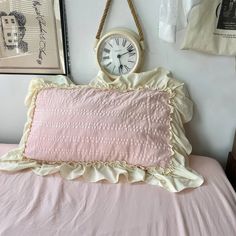 a pink bed with a clock hanging on the wall