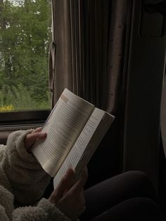 a woman reading a book while sitting in a car