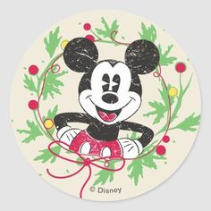 a drawing of mickey mouse sitting on top of a christmas wreath with holly leaves around it