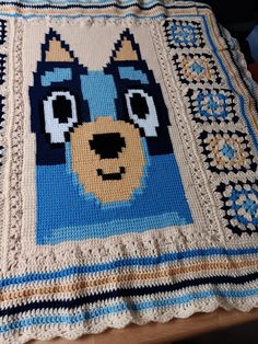 a crocheted afghan with a dog's face on it