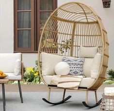 a rattan swing chair with cushions and pillows