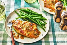 two white plates topped with green beans and chicken