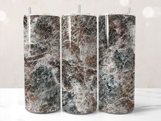 three marbled candles sitting on top of a table