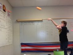 a person throwing an object in front of a whiteboard