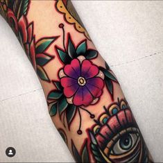 an eye and flower tattoo on the arm